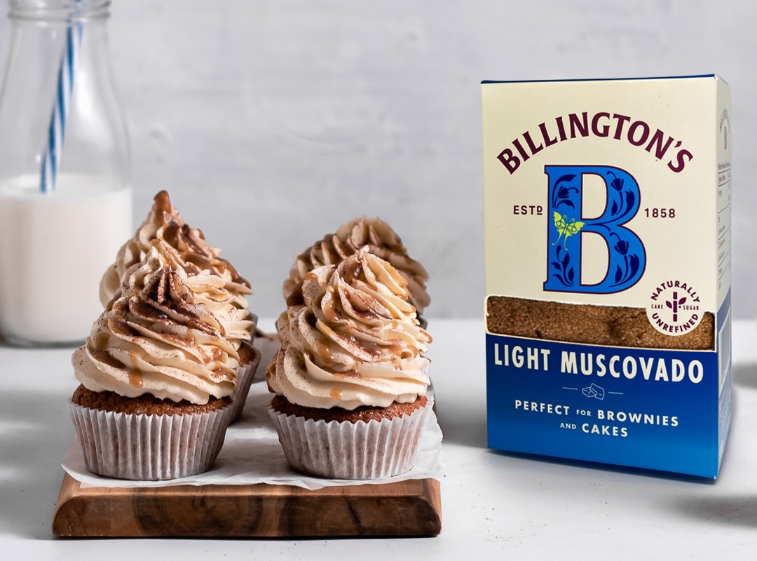 Some homemade cupcakes sitting on a counter alongside a pack of Billington's Light Muscovado sugar.